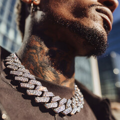 Close-up of diamond Cuban link chain on tattooed man&rsquo;s neck in sunlight