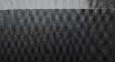 Close-up of dark grey woven material featuring tiny intersecting grid pattern and gradient. Concept for industrial design, futuristic backgrounds and technical specifications renderings