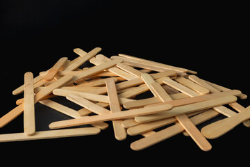 A pile of wooden sticks, some of which are bent, and others are straight. The sticks are all different sizes and shapes