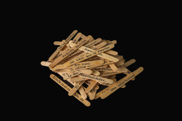 A pile of wooden skewers with words written on them. The skewers are arranged in a way that they look like a stack of books. Scene is playful and creative.
