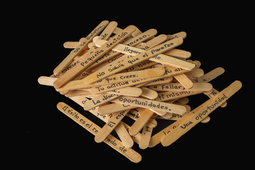 A creative arrangement of wooden skewers with Spanish writing forming a visible message. The skewers are placed together on a surface, symbolizing communication, culture, and handmade craftsmanship.
