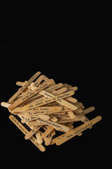 A pile of wooden sticks with Spanish writing on them. The sticks are stacked on top of each other.