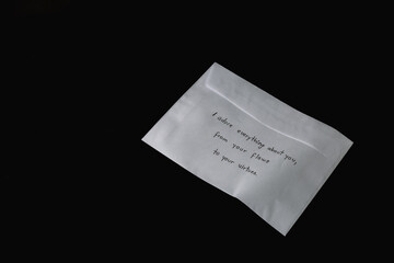 A white envelope with a handwritten message placed on its surface. The envelope symbolizes personal communication, love letters, or meaningful correspondence, evoking intimacy and connection.