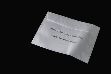 A white envelope with a handwritten message on it. The message reads, 