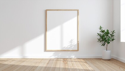 A tall empty rectangular picture frame with a light wood border hangs on a clean white wall bathed in soft sunlight casting geometric shadows on the wooden floor