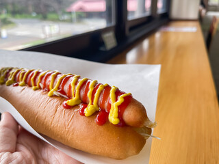トマトケチャップとマスタードソースをトッピングしたジューシーなホットドッグ。