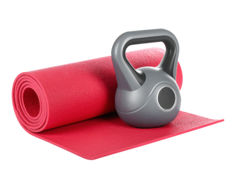 A silver kettlebell placed on a rolled-up red yoga mat.