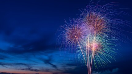 Vibrant fireworks bursting against a deep blue twilight sky