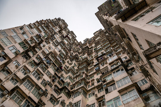 View of the mottled exterior of crowded narrow apartments in a residential tower of an old community in Quarry Bay, Hong Kong, a phenomenon of overpopulation and high housing density