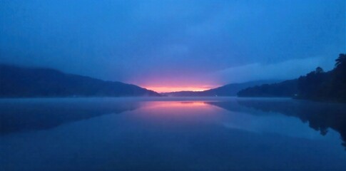 Misty sunrise over a tranquil Russian lake, with fog rolling across the water and obscuring distant shores. A still lake at sunrise, with thick, rolling mist hovering just above the water s surface.