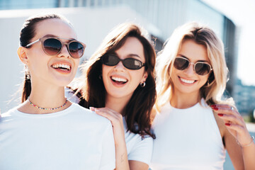 Three young beautiful smiling hipster female in trendy summer same clothes. Carefree women posing...