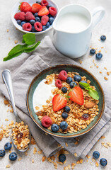 Granola bowls with berries, yogurt, nuts, and honey for breakfast