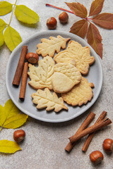 Autumn cookies on plate with cinnamon and hazelnuts