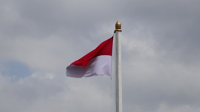 The Indonesian national flag, red and white, flutters in the air
