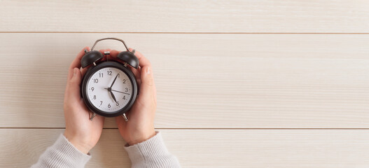Child's hands holding a clock. Children's time, time management, study time, learning time, schedule, planning, etc.  時計を持つ子供の手。子供の時間、時間管理、勉強時間、学習時間、スケジュール、計画など