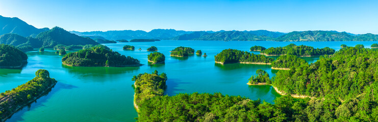 Obraz premium Aerial view of the beautiful lake and green islands with mountain natural landscape on a sunny day. Famous Qiandao Lake scenery in Hangzhou, China.