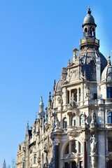 Antwerp architecture with intricate details, ornate facades, and a dominant dome against a clear blue sky