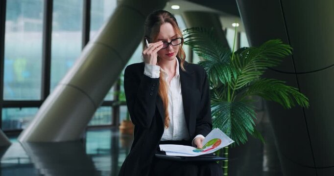 Overwhelmed and upset businesswoman shakes her head in disbelief while reviewing a bad financial report, feeling the stress and pressure of corporate failure