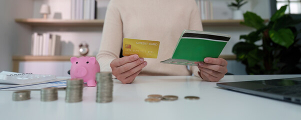 Financial Transactions. Holding a credit card and a green wallet.