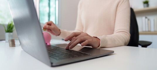 Remote Work. Typing on a laptop with financial tools on the desk.
