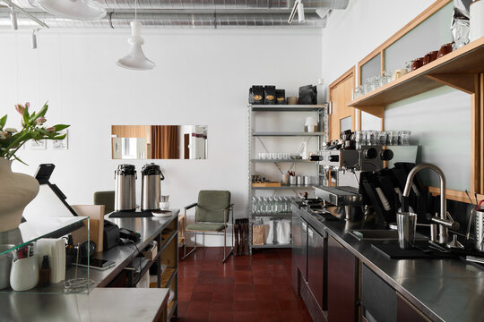 The coffee shop features a clean, modern design with sleek equipment - Powered by Adobe