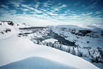 Majestic frozen waterfall in a snowy icelandic landscape