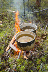 Two pots on fire. Camping dinner cooking