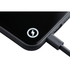Close-up macro view of a smartphone charging port with a lightning bolt indicator glowing