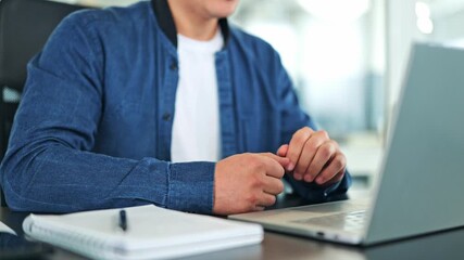 Successful young male in a blue denim jacket and white t-shirt actively communicates on an online video call from a modern office, using a laptop and headset. Professional and engaged specialist.