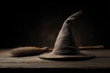Witch hat and broom on dark wood, soft top light, clean shadows, cozy moody palette