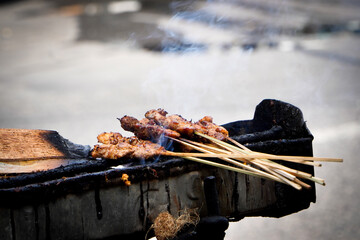 meat on the grill. Chicken satay with charcoal ingredient on red fire grilling by people. traditional satay from Indonesia. cooking satay. Arrosticini italian traditional food. skewered and grille