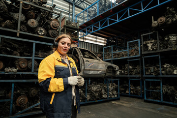 Fototapeta premium Portrait woman Middle east technician or engineer use tablet computer and headphone checking auto part or car part at car part warehouse 