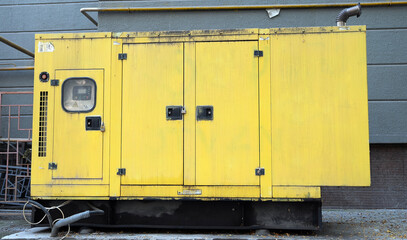close up of a yellow tranformer box in the street