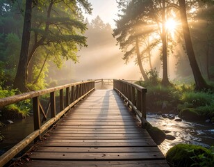 Fototapeta premium Wooden bridge over stream in misty forest at dawn, sun through trees