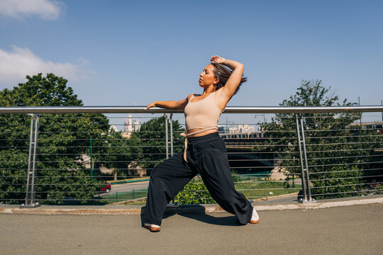 Woman performing modern dance outdoors on a bridge