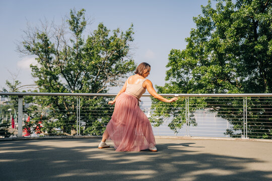 Woman contemporary dancer performing on urban bridge outdoors