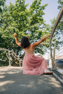 Woman dancing expressing freedom and joy outdoors on bridge