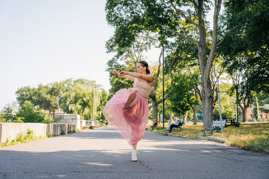 Woman dancing gracefully in park enjoying freedom and motion