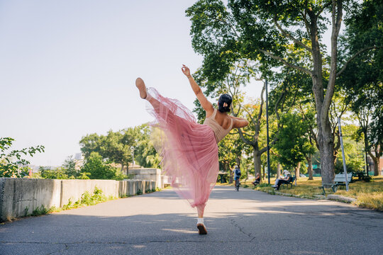 Ballerina performing dance pose in public park