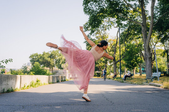 Woman dancing ballet in park during summer day