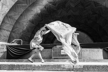 Woman dancing with flowing fabric on outdoor stage