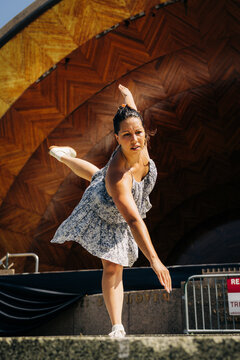 Woman performing modern dance outdoors on stage