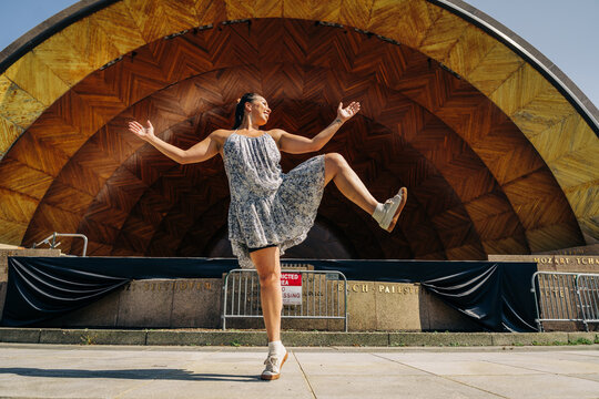 Woman dancing joyfully at hatch memorial shell during summer