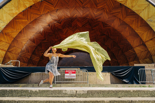 Woman performing free flowing dance with fabric on stage