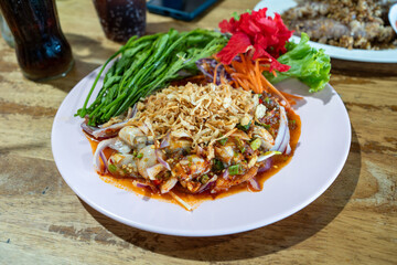 Spicy Thai Raw Oyster Salad (Yum Hoi Nang Rom) on a Pink Plate
