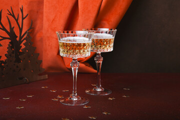Champagne in wine glasses and Christmas decorations on red table. Happy New Year. Festive party. Greeting card or invitation with copy space