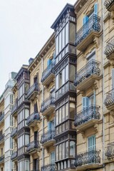 Historic Facade in San Sebastian Spain with Ornate Wrought Iron Balconies and Wooden Bay Windows