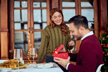 Couple Celebrates New Year Dinner At Home With Gift Box And Cozy Christmas Tree