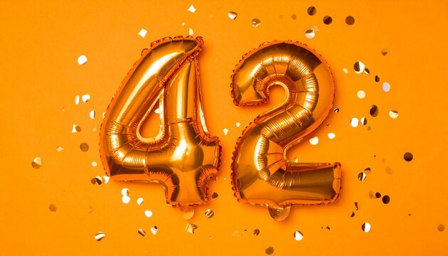 Orange balloon number 42 with confetti on solid colored background. Photo for anniversary or birthday party