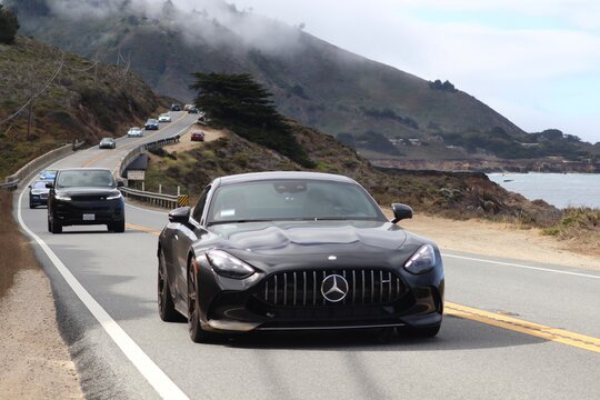 Mercedes sports car in sleek black driving on the road. 